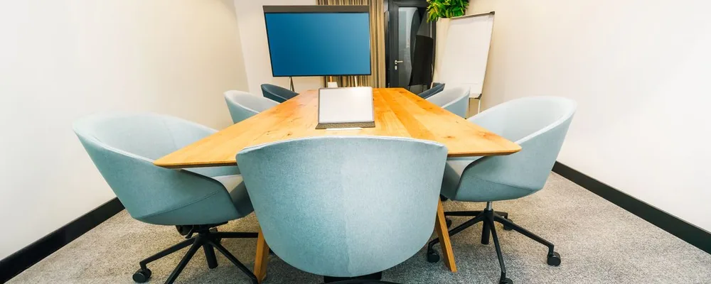 A calendar meeting invite with a room added as a resource alongside the human attendees, showing the room as an accepted participant.